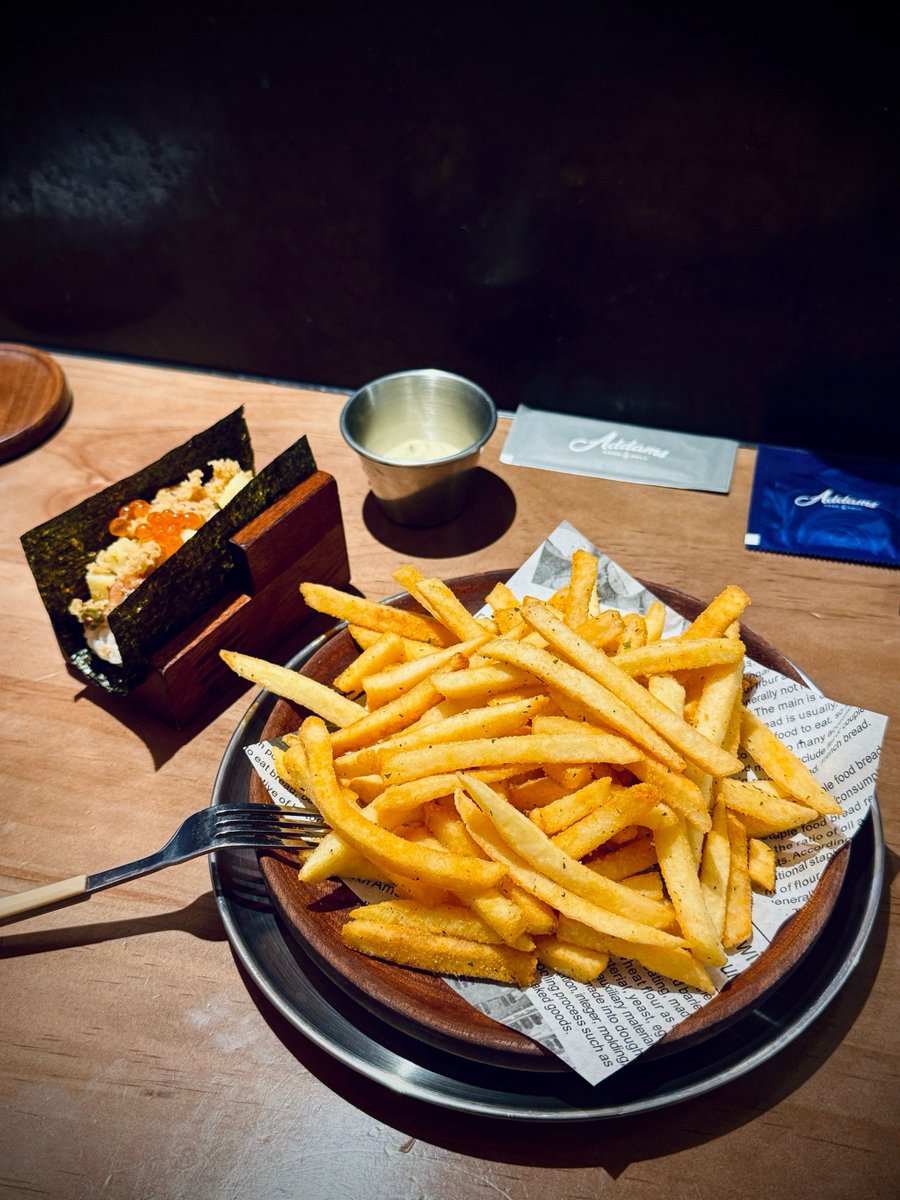 BrittniBilynu's tweet photo. A small rice ball with grilled seaweed sits warm on a wooden plate, under the dim lamp of a late-night stall. Some nights, all you need is one bite of comfort to chase away the weariness. https://t.co/pkAFx1s90n