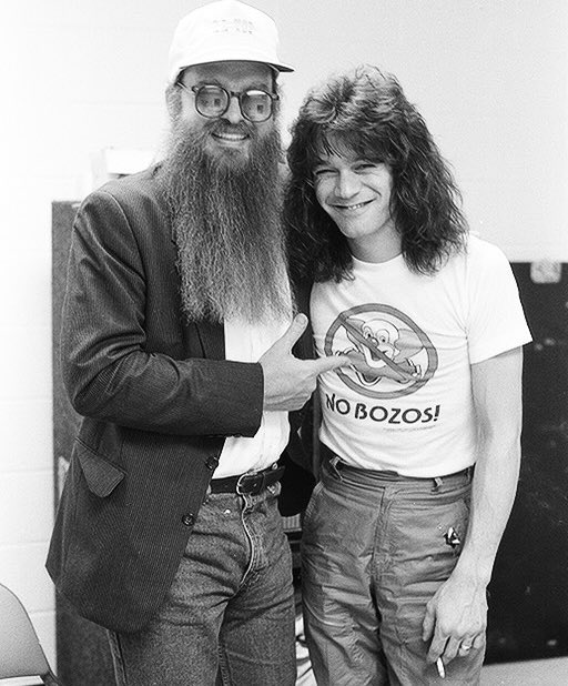 historyrock_'s tweet photo. Eddie Van Halen and Billy Gibbons met when they were both living nearby in Los Angeles, in the years following Van Halen’s debut in 1978. 

Gibbons, already an established star with ZZ Top, had been blown away the first time he saw Eddie play live, immediately recognizing the revolutionary nature of his guitar technique.

What truly brought the two guitarists together, beyond music, was something much simpler. Their shared passion for Mexican food. From that everyday affinity, a genuine friendship was born that lasted for decades, fueled also by the mutual respect between two of the most innovative styles in the history of the electric guitar.

Backstage photos like this one, showing the two sharing laughter and jokes away from the stage, capture precisely that genuine closeness between two rock legends.
