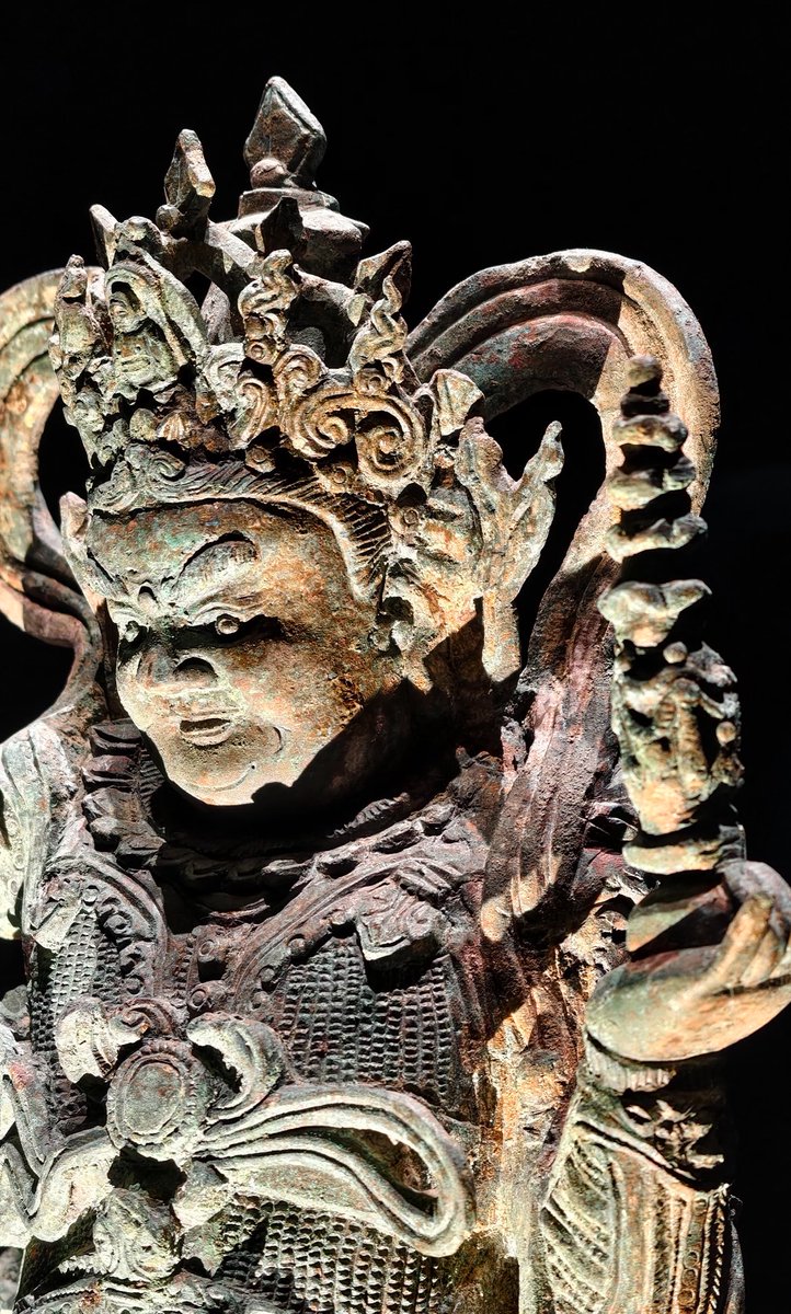 blackym25's tweet photo. 大同窖藏毗沙门天王铜造像（明代），大同关帝庙窖藏出土（1）
Bronze Statue of Vaiśravaṇa, Ming Dynasty. Hoard from Guandi Temple, Datong
2008年大同鼓楼东街关帝庙窖藏出土。
这批窖藏共计57尊佛、道铜造像，是当地信众于明代“戊子之变（姜瓖反正）”战乱之时集中掩埋。全部为���同本地工坊失蜡法铸造，原始通体鎏金。毗沙门即北方多闻天王；此像左手托舍利浮图，右手握吐宝鼠（纽列）；头戴五叶宝冠，脑后缯带飞扬；胸甲饰狻猊兽首吞肩，细密錾刻鳞甲，保留北朝‑辽金一脉相承的北方护法造像范式，铠甲复刻明代九边戍地实战甲胄风貌，雄浑威武。
📷素履｜壁间行