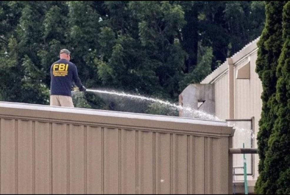 Real_RobN's tweet photo. Here is:

Christopher Wray cleaning up the crime scene—washing the dead assassin’s blood off the rooftop in Butler, Pennsylvania.

FBI agents never clean up crime scenes. It’s not their job. It’s called assassinating the President of the United States, then covering it up. 

Remember, this goes all the way back to the Russian collusion hoax. Barack Obama attempted to frame him—and now, he attempted to kill him.