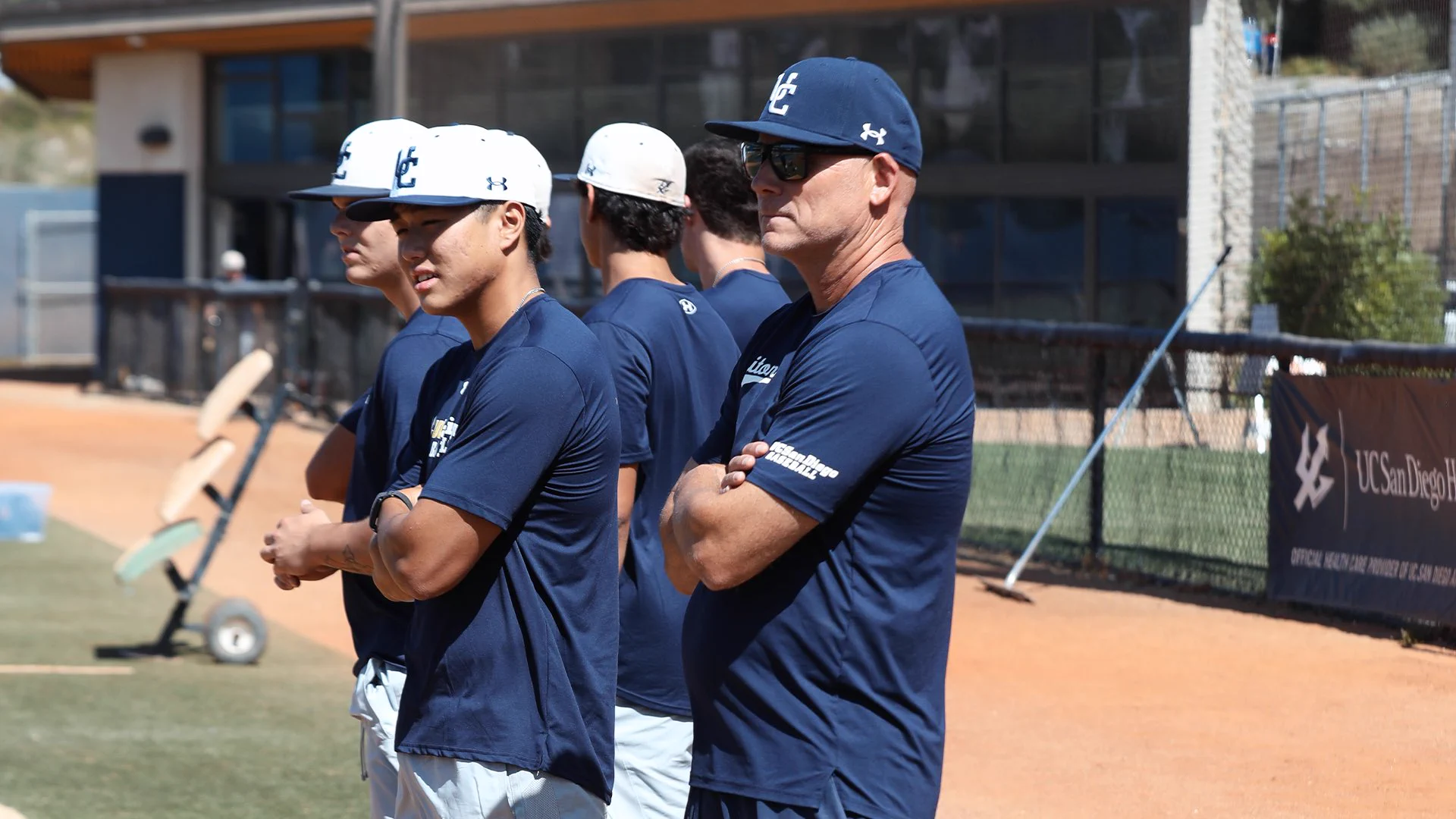 Coach and players observe on field