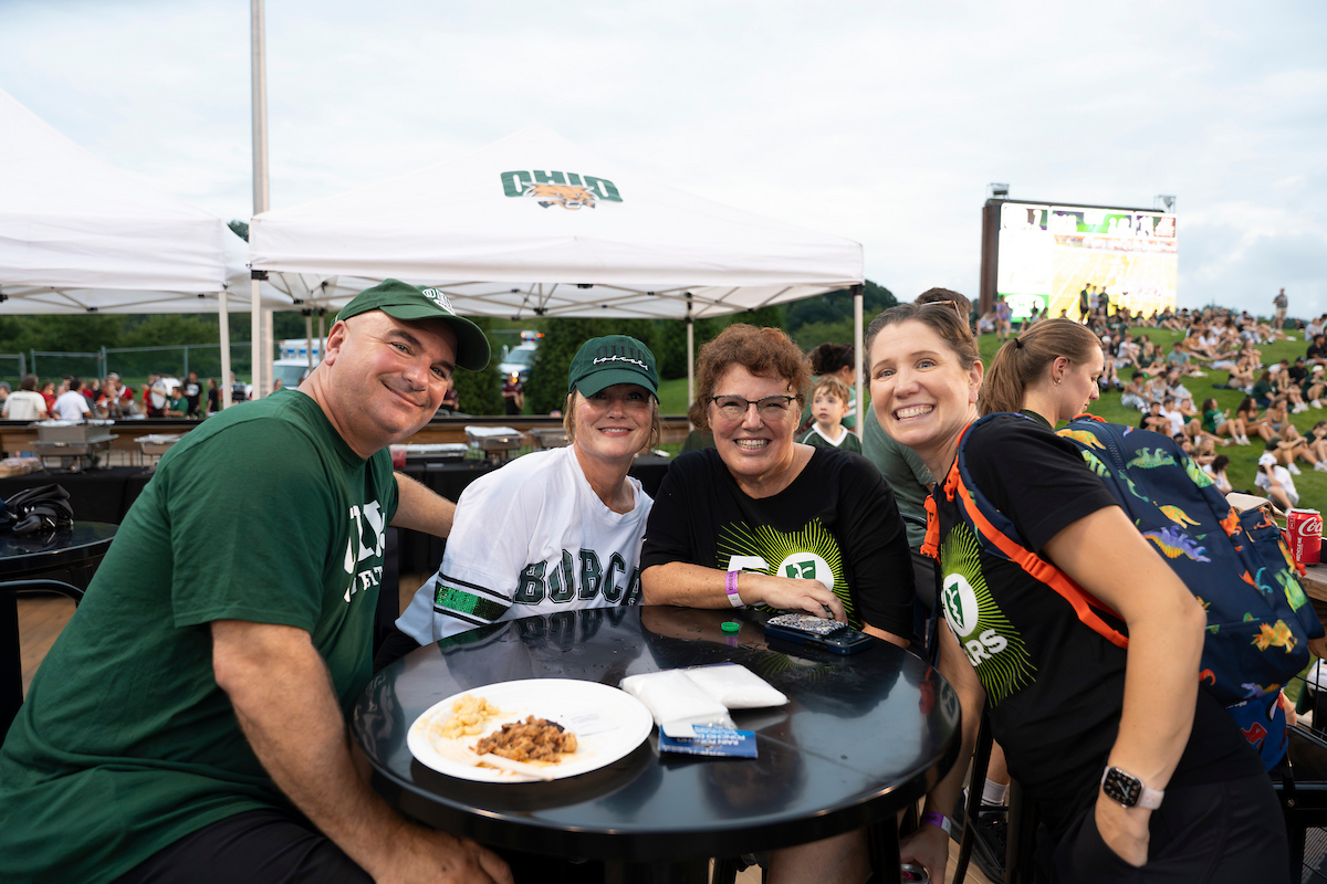 OUHCOM's tweet photo. On Saturday, #OUHCOM sponsored the game between the @OhioBobcats and Jacksonville State. Interim Senior Dean Jennifer Gwilym, D.O., and students stepped on the field to toss T-shirts and celebrate our 50th anniversary during an incredible fourth-overtime win. https://t.co/fCFm3pwiiz