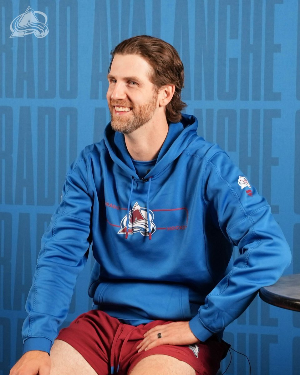 A photo of Scott Wedgewood sitting next to a table smiling toward the camera
