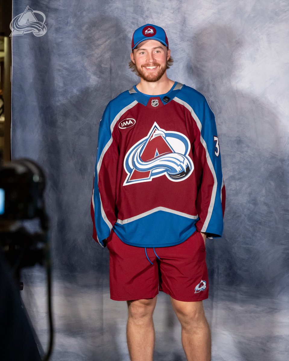 Mackenzie Blackwood standing with his hands in his pockets in front of a blue and white back drop