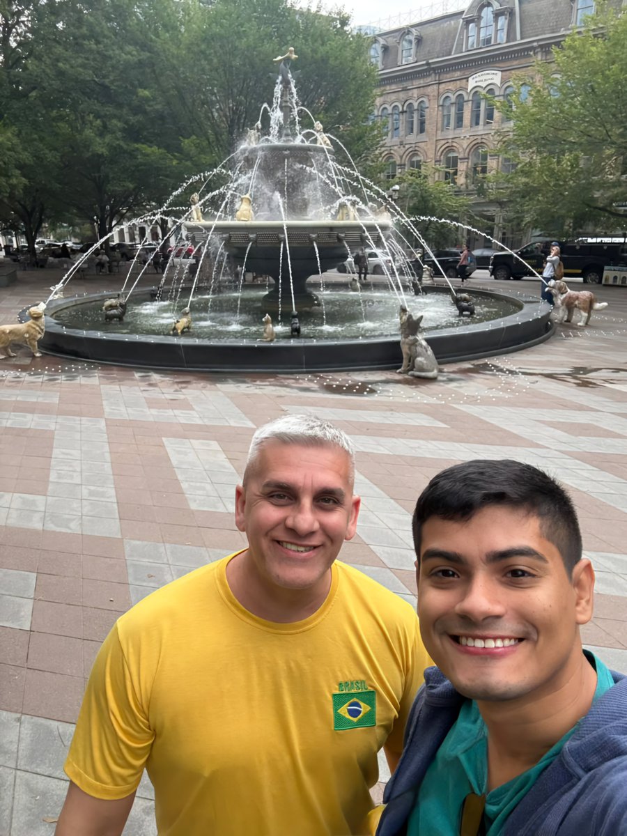 ChristianMaltez's tweet photo. Famosa fonte de cães localizada no Berczy Park. O chafariz possui estátuas de ferro fundido de 27 cães olhando para um osso gigante no topo, além de uma estátua de gato que olha para os pássaros. https://t.co/UzCGY6hXKB