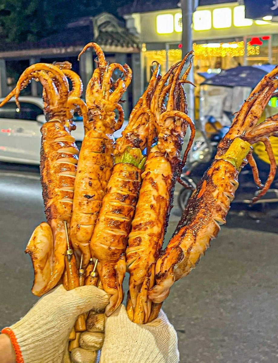 alorw606849's tweet photo. Just found the best late-night street snack—crispy fried squid on a stick with a zesty spicy chili sauce, perfect bite after bite! https://t.co/ZGyFdWjJva