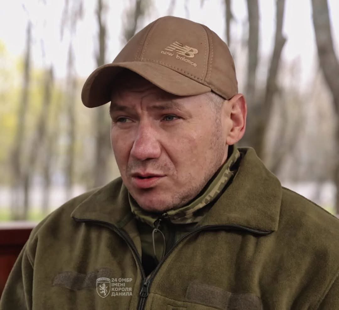 volodarskijo's tweet photo. Він провів 346 днів на позиції під Часів Яром: знищив 23 російських окупанти, а ще шістьох взяв у полон. 

За цей подвиг Сергій Керницький, боєць 24-ї ОМБ, отримав звання Героя України.

У ближньому бою Сергій діяв просто і жорстко: спеціально підпускав ворога на 20–25 метрів, а потім зустрічав гранатою і добивав. 

Каже, що робив це, щоб не промахнутися і бути впевненим, що ворог точно буде знищений. Стріляти здалеку, з-за кущів, сенсу не було.

Весь рік він вів відеощоденник. Знімав усе на звичайний телефон: атаки, трофеї, побут на позиції. 

Зв'язку не було жодного, але телефон працював. Заряджав його від батарей, знятих із захоплених російських гранатометів СПГ. 

Так збереглися сотні коротких відео: як горить бліндаж після влучання запальнички, як він рахує трофейні автомати, як смажить реберце на буржуйці та варить юшку.

До армії Сергій був будівельником на Хмельниччині. Мобілізувався 3 листопада 2024 року. 

Спочатку думав, що пробуде на позиції три місяці, потім ще пів року. А вийшло майже рік. 

Коли питав командира, чому так довго не міняють, відповідь була завжди одна: нема людей, нікого послати.

Позиція - це землянка три на чотири метри під Часів Яром. Пізніше її назвали "Керницькою" на його честь. 

У перший же день заходу на позицію загинув побратим: снаряд пробив стелю і залишив дірку півтора на півтора метри.

Взимку Сергій стояв на спостереженні по дві години поспіль, бо на третю руки заклякали так, що автомат неможливо було перезарядити. 

Бліндаж закладав мішками із землею та трофейними бронежилетами, щоб осколки не залітали всередину. 

Буржуйку вивів трубами далеко через терен і засипав гілками, щоб дим не було видно з повітря і ворог не помітив укриття.

Патрони, гранати і навіть їжу він не просив у командира - усе збирав зі знищеного противника. 

Так він назбирав 12 трофейних автоматів АК-12, бронежилет, лазерний приціл, сухпайки та сигарети.

У кінці січня 2026 року Сергій залишився на позиції сам. Спочатку загинув один побратим від ФПВ-дрона. Потім другий - той, з яким він провів майже рік на позиції. Осколок потрапив йому в артерію. 

Сергій згадує, що зранку вони ще сміялися, а ввечері людина вже була небесною вартою. Просить, щоб земля була йому пухом.

Коли дрони зафіксували групу з восьми росіян, які рухалися захопити позицію, Сергій спалив усі спальники, розібрав трофейні автомати й викинув бойки далеко в поле, щоб нічого не дісталося ворогу. 

Темної ночі він вийшов сам. Ішов як черепаха, бо ноги вже слабо тримали після контузій.

Двох загиблих побратимів забрати з позиції не зміг. Одного трохи присипав землею, другий залишився в бліндажі. 

Сергій каже, що сам себе не може виправдати. Не знає, як пояснити це рідним і як дивитися їм в очі. Каже, що це страшно.