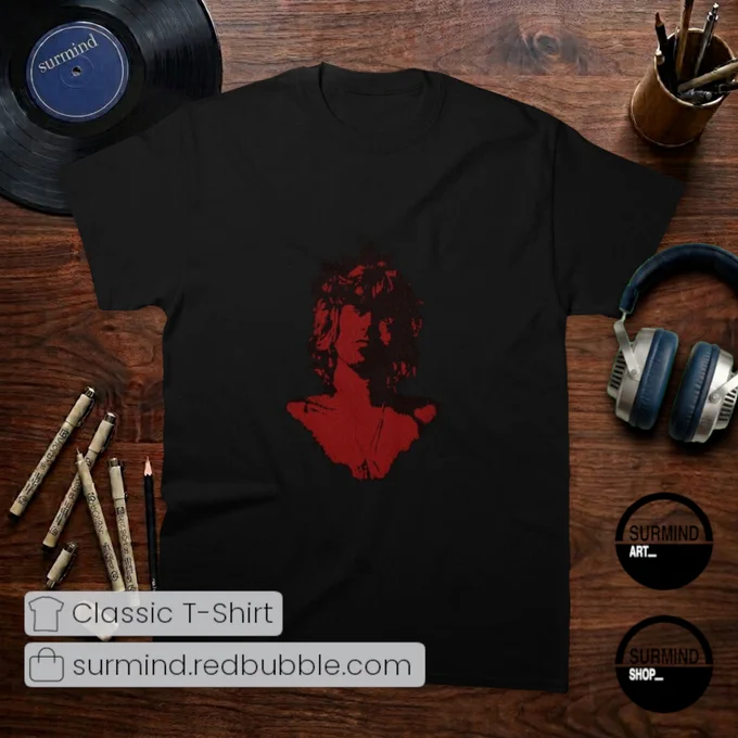 A full flat-lay view of a black classic t-shirt featuring a high-contrast graphic centered on the chest. The design depicts a bust portrait of musician Keith Richards with shaggy hair, staring directly forward. The deep crimson-red artwork is detailed with a fine cracked-texture pattern across the image against the black fabric of the shirt.