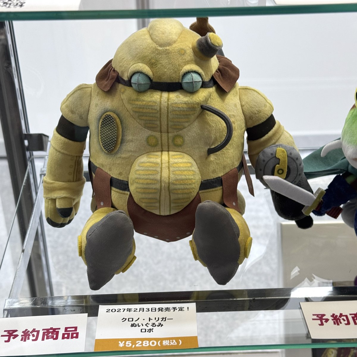 famitsu's tweet photo. スクエニ物販ブースで『クロノ・トリガー』ロボ、カエル、ヌゥのぬいぐるみ実物を展示中

ちょこんと座る姿がかわいい！

#TGS2026 https://t.co/t1WYIQa3E6