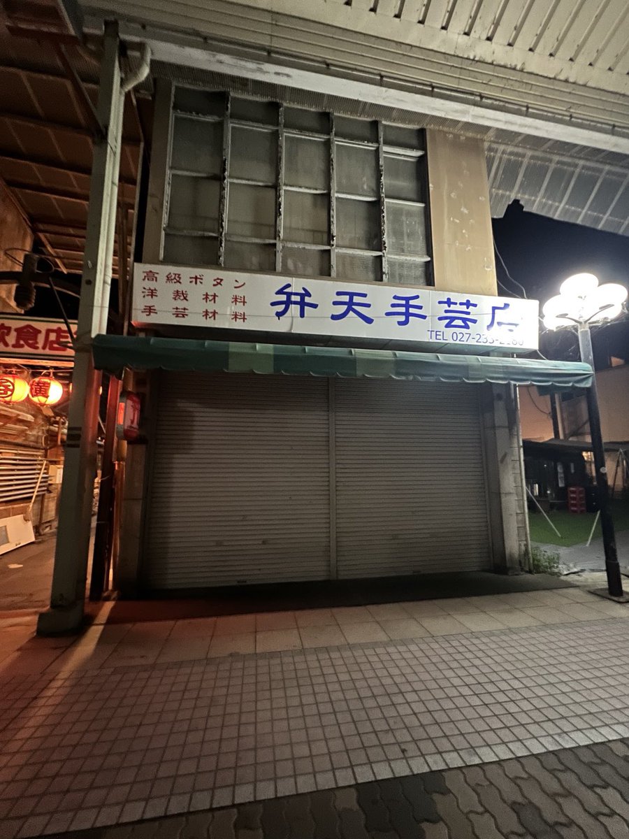 harune_log's tweet photo. ちなみに、夜の弁天通りはまた違った雰囲気👻

赤い提灯が灯る呑龍飲食店街と、隣にある『近畿地方のある場所について』にも登場した弁天手芸店が怪しげな雰囲気

人通りの少ない夜の商店街は、まさにホラー映画の世界みたい https://t.co/f25d94ceTX