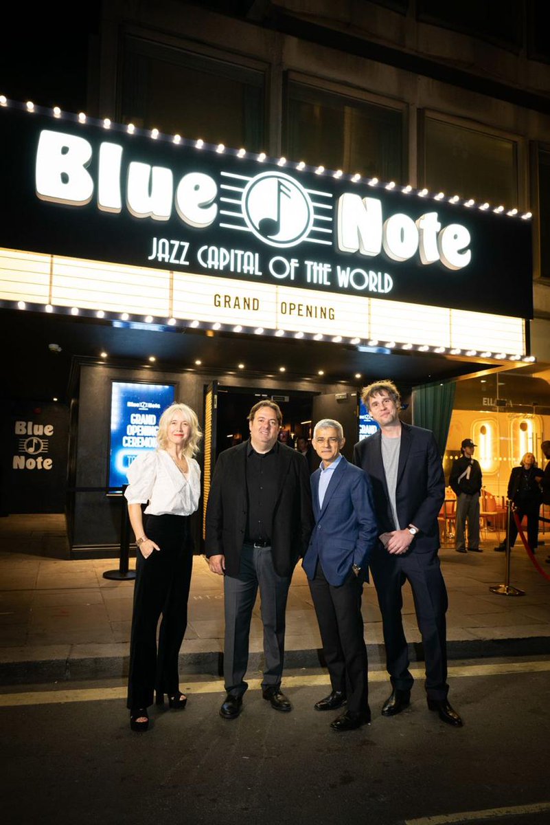 The Mayor of London stands with three guests outside the entrance to Blue Note London. The illuminated venue sign reads “Blue Note – Jazz Capital of the World,” with “Grand Opening” displayed underneath.