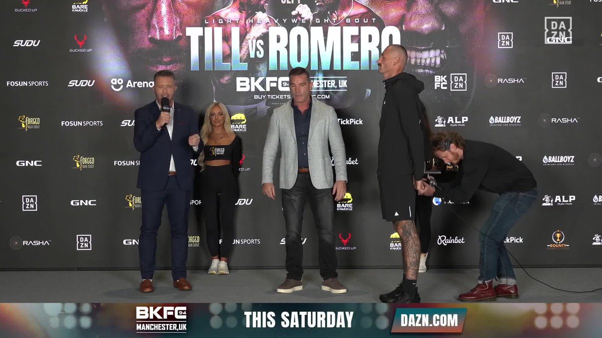 A press conference stage for the BKFC 94 bare-knuckle boxing event features "Till vs Romero" prominently displayed, with fighters Dave Mundell and Jack Cullen standing face-to-face in a tense staredown, while an announcer speaks into a microphone beside a promotional model and another crew member. The on-screen graphic reads "THIS SATURDAY" alongside "DAZN.COM" and "BKFC 94 MANCHESTER, UK," promoting the upcoming bout streaming live on DAZN on September 26.