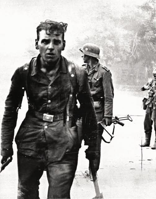 archeohistories's tweet photo. A German Wehrmacht soldiers returning from intense urban combat in Novorossiysk, Russia, during WWII in 1943. The historical image is documented as being taken during street fighting in the port city of Novorossiysk on the Eastern Front... 

German soldiers are pictured in the Black Sea port city after intense street fighting. One man carries a pistol in one hand and an entrenching tool in the other — equipment that could become a formidable close-combat weapon when fighting collapsed into rooms, trenches and ruined buildings. German entrenching tools were primarily intended for digging defensive positions, but they were also used in close-quarter fighting on the Eastern Front.

The combination certainly conveys the nature of the fighting, although the photograph alone cannot prove that he had literally just been involved in hand-to-hand combat.

Novorossiysk was strategically important because of its harbour on the Black Sea. German forces captured most of the city in September 1942 during the drive into the Caucasus, but Soviet troops continued to hold positions nearby.

In February 1943, Soviet forces established the famous Malaya Zemlya — “Little Land” — bridgehead south of the city. For months, German and Soviet troops fought over the surrounding heights, industrial areas and approaches to the port.

The final Soviet assault began on the night of 9–10 September 1943. Troops attacked simultaneously from land and sea, with Soviet marines landing directly in the heavily defended harbour. Fighting inside Novorossiysk became extremely violent, with battles for individual buildings, streets, staircases and defensive positions.

By 16 September, German forces had been driven from the city. Its loss helped undermine the entire Axis position on the Taman Peninsula, which German forces abandoned during the following weeks.

This photograph captures something easily forgotten when looking at maps and arrows showing armies advancing and retreating.

At street level, the Battle of Novorossiysk was fought at terrifyingly close range — sometimes with pistols, grenades, bayonets and even the ordinary soldier's entrenching tool.

#archaeohistories
