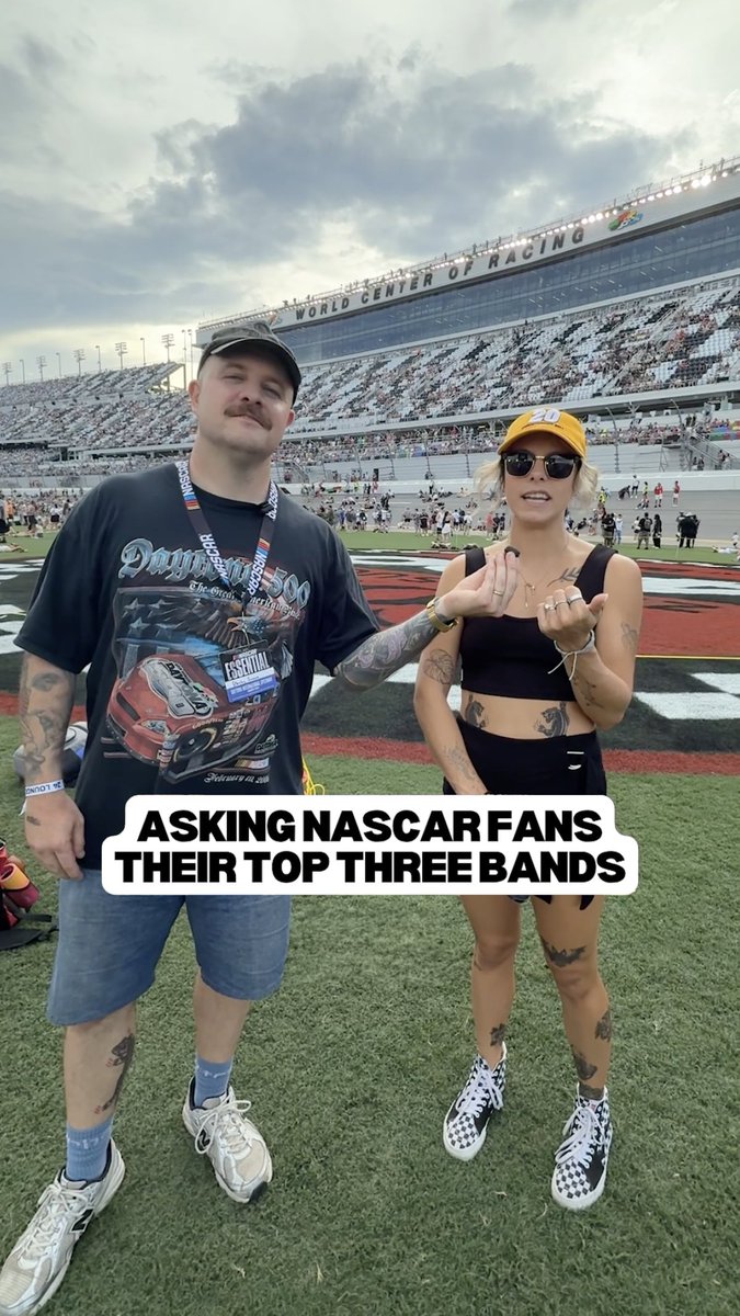 A man in a Daytouna NASCAR shirt and a woman in a yellow cap pose together at the World Center of Racing speedway, with a text overlay reading "ASKING NASCAR FANS THEIR TOP THREE BANDS." The image relates to the post's humorous premise of asking NASCAR fans at a race to name three bands for the Rockville music festival.