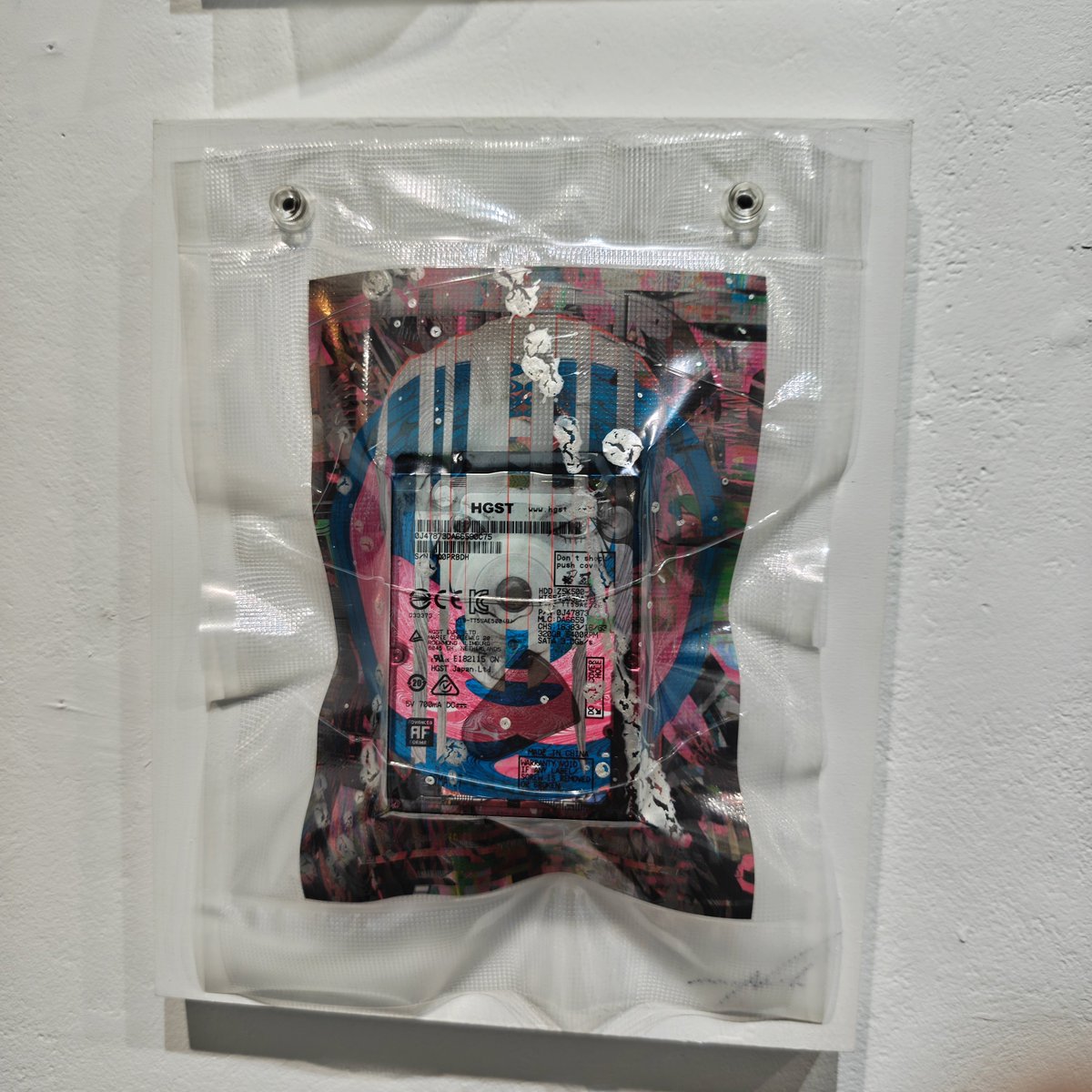 GraphicNakamura's tweet photo. 今回のアトリエ三月のFLAG2026で出してる作品はプリント アクリル絵具 デジタルデータと全部入りなので残ると思ってる。（デジタルデータをプリントしたシートにアクリル絵具で加筆し
デジタルデータを保存したハードディスクと一緒に真空パックされている。） https://t.co/pVvcQBrkVe