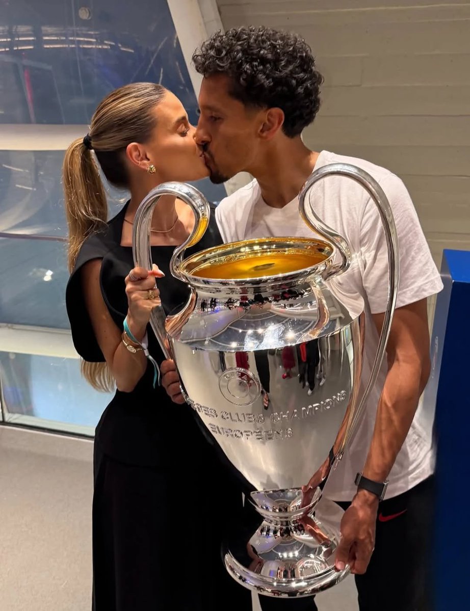 Paristeamfr's tweet photo. On dit souvent que derrière un grand homme, il y a une grande femme. Derrière Marquinhos, il y a Carol. Nous, supporters, nous avons vu notre capitaine grandir sous nos couleurs, gagner, perdre, pleurer, être critiqué, parfois terriblement, puis se relever encore et encore. Mais lorsque les lumières du Parc s’éteignaient et que Marquinhos rentrait chez lui avec ses blessures, ses doutes ou ses déceptions, il y avait une femme pour accueillir l’homme derrière le footballeur. 

Une femme qui a traversé avec lui toutes ces années parisiennes, les éliminations qui ont laissé des cicatrices, les soirées où tout semblait s’écrouler, les critiques qui pouvaient être difficiles à encaisser, mais aussi les naissances, les joies, les titres et cette famille qui s’est construite avec Paris en toile de fond. Carol était là quand Marquinhos rêvait encore de soulever cette Ligue des Champions avec le PSG. Elle était là quand ce rêve paraissait si loin. Et elle était là lorsque son mari, après toutes ces années, a enfin pu lever cette Coupe en tant que capitaine. Cette image appartenait à Marquinhos, à ses coéquipiers et à tous les supporters, mais elle appartenait forcément un peu à Carol aussi. 

Parce qu’elle seule sait réellement ce qu’il a fallu traverser pour arriver jusque-là. On parle souvent de la force de notre capitaine. Une partie de cette force vient certainement de cette famille qui l’accompagne lorsque personne ne regarde. Alors aujourd’hui, j’avais simplement envie d’avoir une pensée pour Carol. Parce que derrière le Marquinhos que nous aimons, derrière notre capitaine, derrière l’homme qui a consacré une immense partie de sa vie au PSG, il y a aussi une femme qui a vécu toute cette histoire à ses côtés. Et après tant d’années, Carol fait forcément, elle aussi, un peu partie de notre famille Rouge et Bleu. ❤️💙