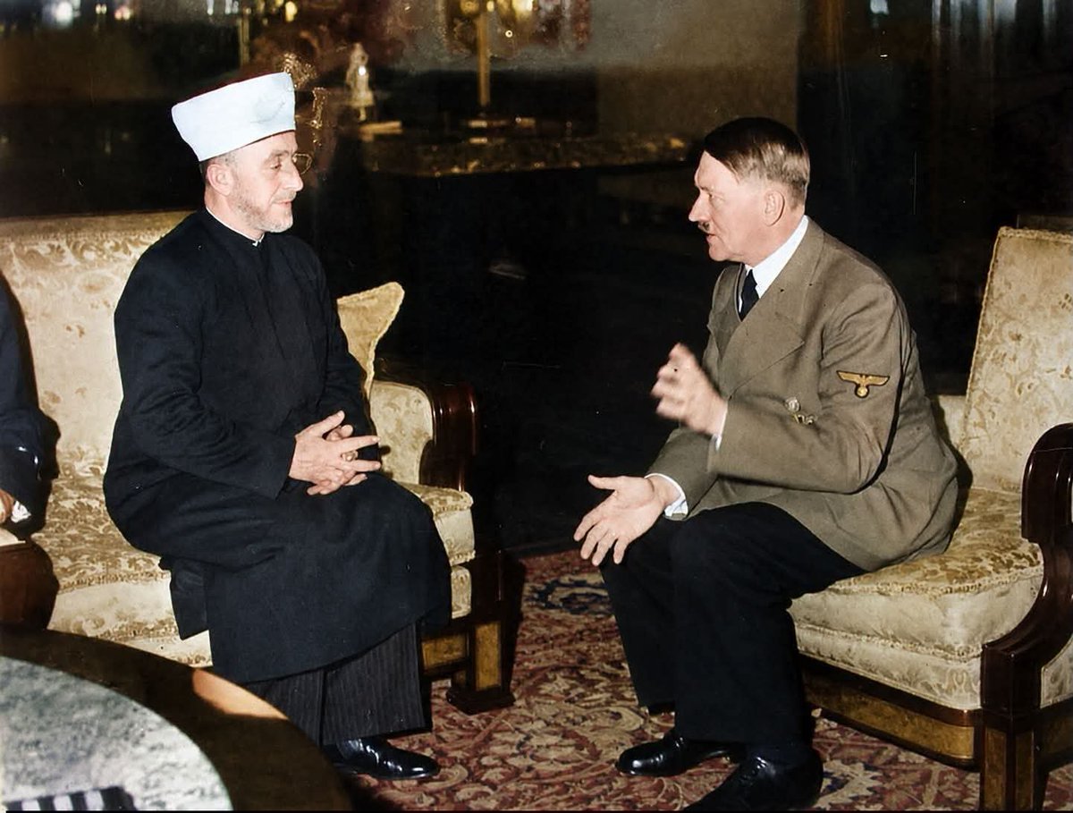 archeohistories's tweet photo. Adolf Hitler meeting with the Grand Mufti of Jerusalem, Haj Amin al-Husseini, in Berlin on November 28, 1941. The meeting took place at the Reich Chancellery, where they discussed geopolitical cooperation and shared opposition to British influence and a Jewish national home in Palestine...

Amin al-Husseini was born in Jerusalem near the turn of the 20th century, Husseini came from a prominent Palestinian family. In 1921, Palestine’s British rulers installed him as grand mufti of Jerusalem, a religious leadership position.

Husseini was an advocate for Arab nationalism, and in 1936 he joined with other Palestinian leaders in revolt against British. The revolt lasted until 1939, claimed thousands of lives, including hundreds of Jews and led British to seek an exit from the territory. In 1937, British removed Husseini from his position, prompting him to flee to Lebanon.

During WWII, Husseini supported an anti-British rebellion in Iraq and became rebels’ envoy to Germany and Italy. When rebellion was suppressed, he fled to Italy and continued his contacts with Axis powers from there, famously meeting with Adolf Hitler in November 1941. He continued to support Nazis in various ways throughout the war. After the war, Husseini escaped to Beirut, his influence diminished. He died there in 1974.

Husseini opposed any accommodation of a Jewish national home in what would become Israel. He opposed 1939 British White Paper, despite its ban on Jewish immigration to Palestine, because it set too long a timeline for an Arab state. And he opposed 1947 United Nations partition plan that sought to create neighboring Jewish and Palestinian states. Husseini also backed violence against Jews. In 1920, he organized an anti-British demonstration in Jerusalem that grew violent and was subsequently convicted of incitement.

In early 1940s Husseini was seeking German support for Arab independence from colonial rule, and records of the meeting show that Husseini focused his requests on a formal Nazi declaration of support for “the independence and unity of Palestine, Syria, and Iraq” under Arab rule. According to the British record, Husseini told Hitler, “The Arabs were Germany’s natural friends because they had the same enemies as had Germany, namely English, Jews and Communists.” He also thanked Hitler for supporting “the elimination of the Jewish national home.” The record does report that Hitler announced his intentions, noting that he planned to “ask one European nation after the other to solve its Jewish problem.”

According to some unverified sources, Hitler promised the Mufti of Jerusalem that he would also eliminate Jews in Palestine. With this, he wanted to torpedo the British partition plan for Mandate territory. This plan envisioned creating a "Jewish homeland" in part of Palestine. Mufti didn't want that, and neither did Hitler. Extermination of the Jews in Palestine was to be only the beginning. Once Russian campaign was over, all remaining Jews in Arab world would be annihilated, Hitler promised the Mufti. For the first time, envisioned Final Solution was to take place outside of Europe. Amin al-Husseini announced plans to form Muslim SS units in Balkans and North Africa. They were to support North African campaign led by Erwin Rommel, where Wehrmacht encountered fierce resistance from British army.

According to Maoz, Palestinians today see Husseini as one of their national fathers. But their admiration is mitigated, he said, because Husseini was so strongly pro-Nazi and was ineffective in advancing the Palestinian cause.

His stature among Palestinians, Maoz said, pales to that of Yasser Arafat, whose memory enjoys near universal reverence. But Palestinians tend not to criticize Husseini in public, Maoz said, because they want to display unity.

“Not a few Palestinians think he wasn’t so positive,” Maoz said. “He was very stubborn. But those who oppose him don’t emphasize it out of solidarity.”

(Colorized Photo) 

#archaeohistories