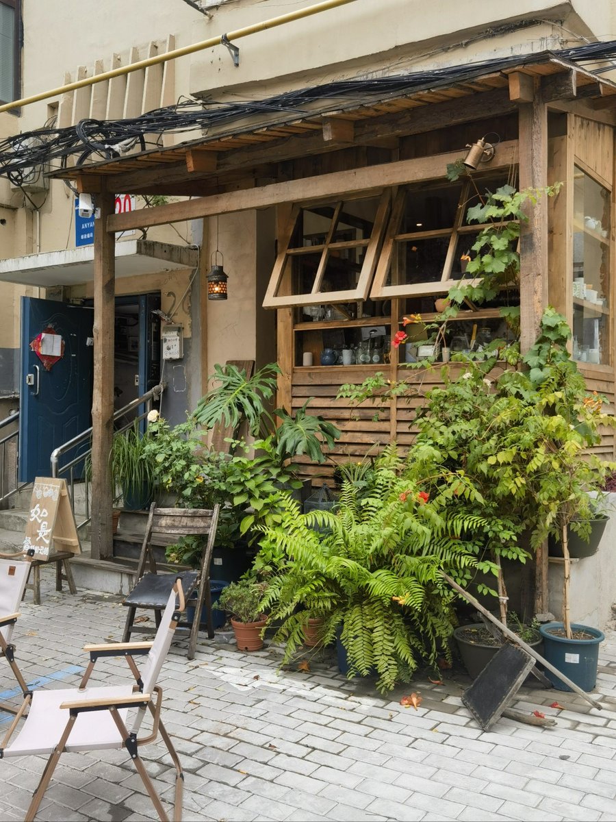 RoyRossf2cf's tweet photo. Just a quick street snap – the golden afternoon light hitting a retro bike lined with potted flowers by a corner café. Nothing fancy, just that quiet, warm urban vibe. https://t.co/OezRCfrFU2