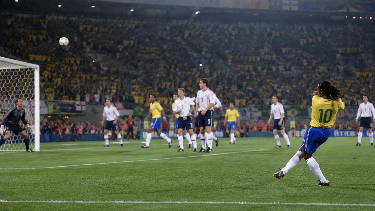 SoccerAmplified's tweet photo. DID YOU KNOW RONALDINHO'S 2002 WORLD CUP FREE-KICK CREATED A DEBATE THAT STILL HASN'T DISAPPEARED?

Brazil faced England in the quarter-finals of the 2002 FIFA World Cup.

Michael Owen had given England the lead before Rivaldo equalised in first-half stoppage time.

The score was 1-1 when Ronaldinho stood more than 35 yards from goal and wide on the right.

David Seaman was positioned off his line.

Ronaldinho struck the free-kick with power and spin.

The ball travelled over Seaman and dropped into the top corner.

Brazil won 2-1 and advanced to the semi-finals.

A debate began immediately over Ronaldinho’s intention.

England players believed he had tried to cross.

Ronaldinho insisted he had deliberately attempted a shot.

FIFA recorded his response as unequivocal: it was definitely a shot.

He later accepted that the ball did not travel exactly where he expected.

Whatever interpretation is placed on the strike, it became one of the most famous free-kicks in FIFA World Cup history.

#Ronaldinho #Brazil #England #WorldCup #FIFA #FootballHistory #DidYouKnow #FootballFacts