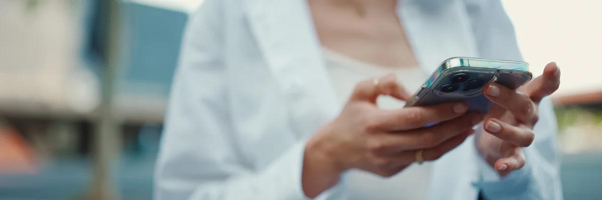 Close-up of a person holding and scrolling a smartphone.