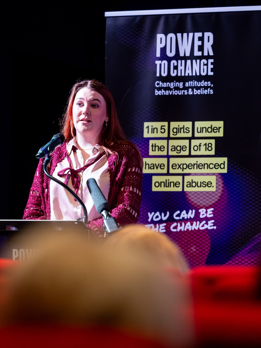 VAWG Victim Jodie speaking at a podium in front of a 'Power to Change' campaign banner.