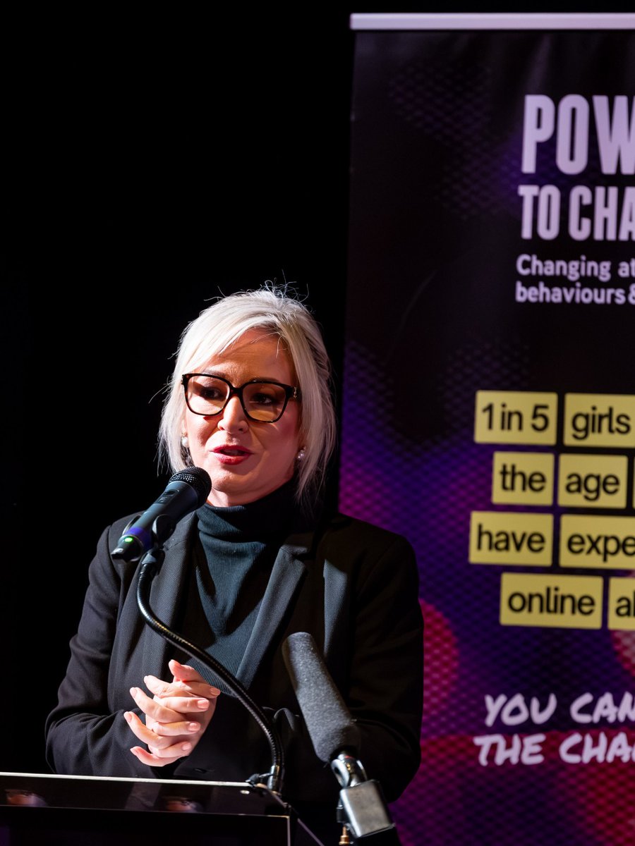 NI First Minister Michelle O'Neill speaking at a podium in front of a 'Power to Change' campaign banner.