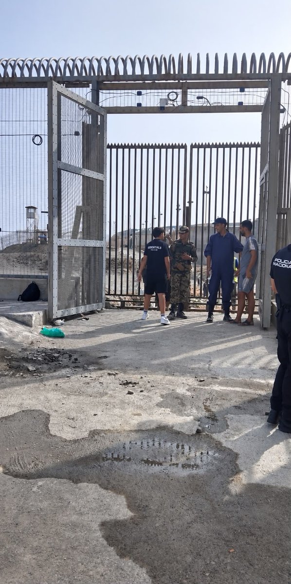 MAngelSilva's tweet photo. #EXCLUSIVA Marruecos evita el retorno de inmigrantes. Construye una puerta en la frontera delTarajal y la cierra a candado. En la foto un Mkhazni (militar marroquí) en TERRITORIO ESPAÑOL impidiendo el paso a 3 personas. La puerta se habría construido del 17/08 al 19/08 🚫USARFOTO https://t.co/OmKoxdD2Jc