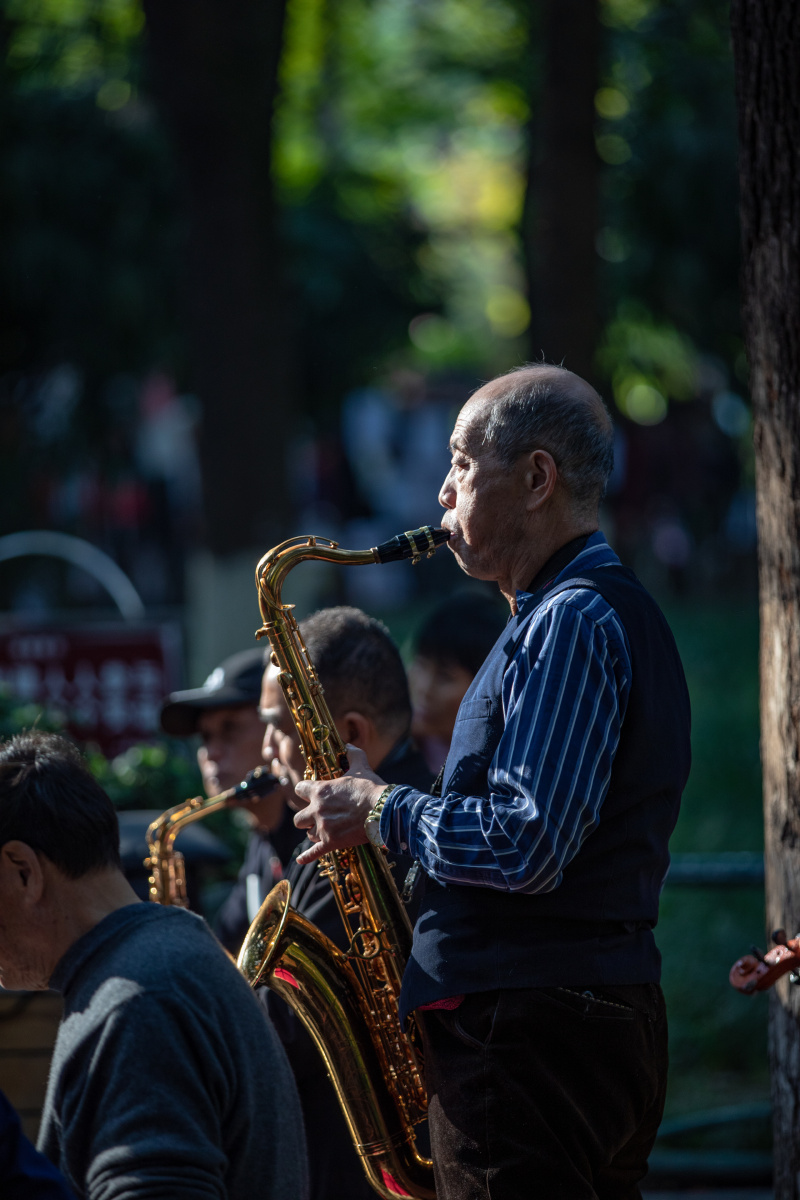 blosr397148's tweet photo. Vintage street corner, old man playing sax under tree—golden hour light makes it feel like a soft, hidden melody. https://t.co/4sSwulzPec