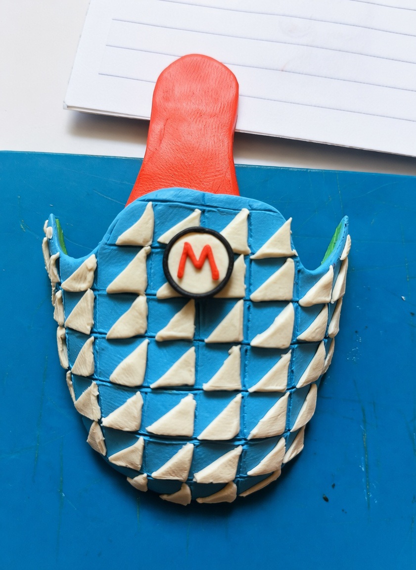 planetspho's tweet photo. It all starts with a sketch and hours of patience. 📜✍️Every single white triangle on that blue pattern was individually cut and placed using a toothpick.🪄 No 3D printers or digital scaling. Just high-precision plasticine work and a passion for retro gaming. 🍄🎮 https://t.co/tUfN4deKwH