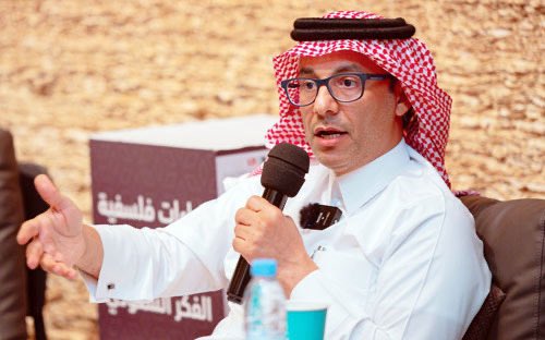 AYPhilosopher's tweet photo. ماذا يعني غيابُ رئيس جمعية الفلسفة السعودية، وأبرز الأصوات المشتغلة بالفلسفة في المملكة العربية السعودية والوطن العربي عن مؤتمر الفلسفة بالرياض، وفي دورته التي حملت عنوان «الفلسفة بين الشرق والغرب»؟ أعني بذلك الدكتور عبدالله المطيري.

المطيري ممن اشتغل بالفلسفة في مرحلة لم تكن فيها هذه الكلمة مألوفة كما هي اليوم، وكان الاقتراب منها لدى كثيرين مدعاة للريبة وربما تهمة من التهم. وهو صاحب واحد من أهم المتون الفلسفية المعاصرة في سياقنا؛ أعني كتاب «فلسفة الآخرية: الآخر بين سارتر وليفيناس وبهجة الضيافة». ولهذا الشيء تحديدا كان غيابه عن مؤتمر في الرياض حمل عنوان «الفلسفة بين الشرق والغرب»، عصي على الفهم عندي. فهذا هو السؤال الذي اشتغل عليه المطيري فلسفيا؛ إذ دخل في حوار مع تصورات غربية عن الآخر، ثم أعاد بناء المسألة من موضعه هو، حيث تتقاطع خبرة الضيافة من سياقه هو مع أسئلة الآخر في الفلسفة القارية. هكذا أفهم كتابه، ومن الصعب استيعاب أبعاده كاملة من دون قراءة السياق الذي ينطلق منه المطيري، وطبعا إلى جانب استعراضه وتأويله لما تحاور معه من الفلسفة الغربية.

لكن سأترك كُتبه ومحاضراته جانبا، فهي معروفة ولا تحتاج إلى تعريف، لكنني أود سرد موقف شخصي يبدو عادي، ولكنه كبير في دلالته… عن جانب المروءة والإنسانيّة عند الفيلسوف العربي. وأعلم أن الدكتور عبدالله سيغضب مني لأنني أرويه دون استئذانه، لكنني أجد نفسي مدفوع بواجب أخلاقي، وشهادة في مشهدنا الفكري، وهي صورة لمعنى المسؤولية الفكرية.

في فترة البحث عن عمل ومحاولة شق طريقي، كانت تصلني رسائل من جمعية الفلسفة تُنبهني إلى قرب انتهاء عضويتي. ومبلغ الاشتراك الذي يبدو بسيط لمن استقرت به الحياة، لم يكن كذلك لشاب في مقتبل طريقه، والكرام أمثال الدكتور عبدالله يلمحون مثل هذه التفاصيل وهي طايرة. 

لم يكن يعرفني أحد من الجمعية عن كثب، ولم أكن أعرف أنا أحد إلا الدكتور عبدالله. لا أعرف كيف انتبه الدكتور للأمر، ولا كيف عرف أنني لم أجدد العضوية أو أن ذلك كان يشكل عبئ علي، لكنه بادر بمراسلتي في الواتساب ليخبرني بأنه سددها نيابة عني، ثم أتبعها بعبارة مفادها «وجودك مهم، وعليك أن تستمر معنا».

في تلك اللحظة، انفتح لي معنى آخر لبهجة الضيافة. فالجانب الأخلاقي والإنساني في عبدالله المطيري يتجاوز كتبه، الرجل يملك قدرة نادرة على الشعور بالآخر، والانتباه إليه، وإفساح مكان له من غير استعراض ولا منّة. وأذكر أن أول لقاء جمعني به كان عام 2023 م، بعد تخرجي بنحو عام، وقلت له حينها عبارة ما زلت أؤمن بصحتها «يا دكتور عبدالله، أنت تشبه مفهوم الضيافة الذي تكتب عنه؛ أنت تجسيدٌ لما تكتب». لأن الحديث معه مريح على نحو نادر، إذ يحرص في حواراته الفلسفية -بطريقة ما- على ألا ينخفض صوتك أمام صوته، ولا يطالبك بأن تتوارى ليبرز هو، وعلى نحو ما، يجعل الحوار يتسع لكما معا.

لكن يؤسفني جدا أنني حين حضرت مؤتمر الفلسفة الأخير، وبحثت عن الدكتور عبدالله المطيري؛ الذي كنت أعود إليه ليشرح لي بعض المفاهيم الفلسفية، والذي أعده أحد أهم فلاسفتنا ومفكرينا، لم أجده؛ لا في الجلسات، ولا حتى في ركن الجمعية. رئيس جمعية الفلسفة السعودية ليس موجود في مؤتمر الفلسفة في الرياض!

ربما لم تصل إليه الدعوة، أو لعلها أخطأت طريقها. ولا يقنعني تفسير "الوجوه الجديدة"؛ فقد رأيت في المؤتمر نفسه أسماء أكاديمية تكررت في معظم دوراته، وبعضها يعيد الأفكار ذاتها تقريبا ولا يتغير فيها إلا العنوان. ولا أظن أن هناك أحد بلغ من الضرورة الفلسفية حد يقتضي هذا الحضور المتكرر على حساب مفكرينا وفلاسفتنا، إلا إذا كان أرسطو جديدا قد تجسد فيه ولم يخبرنا أحد، فتلك حكاية أخرى طبعا.