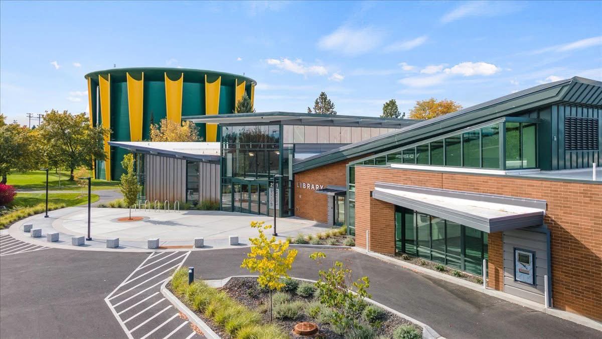 Shadle Park Library, with the green and yellow water tower in the background, on a sunny day.