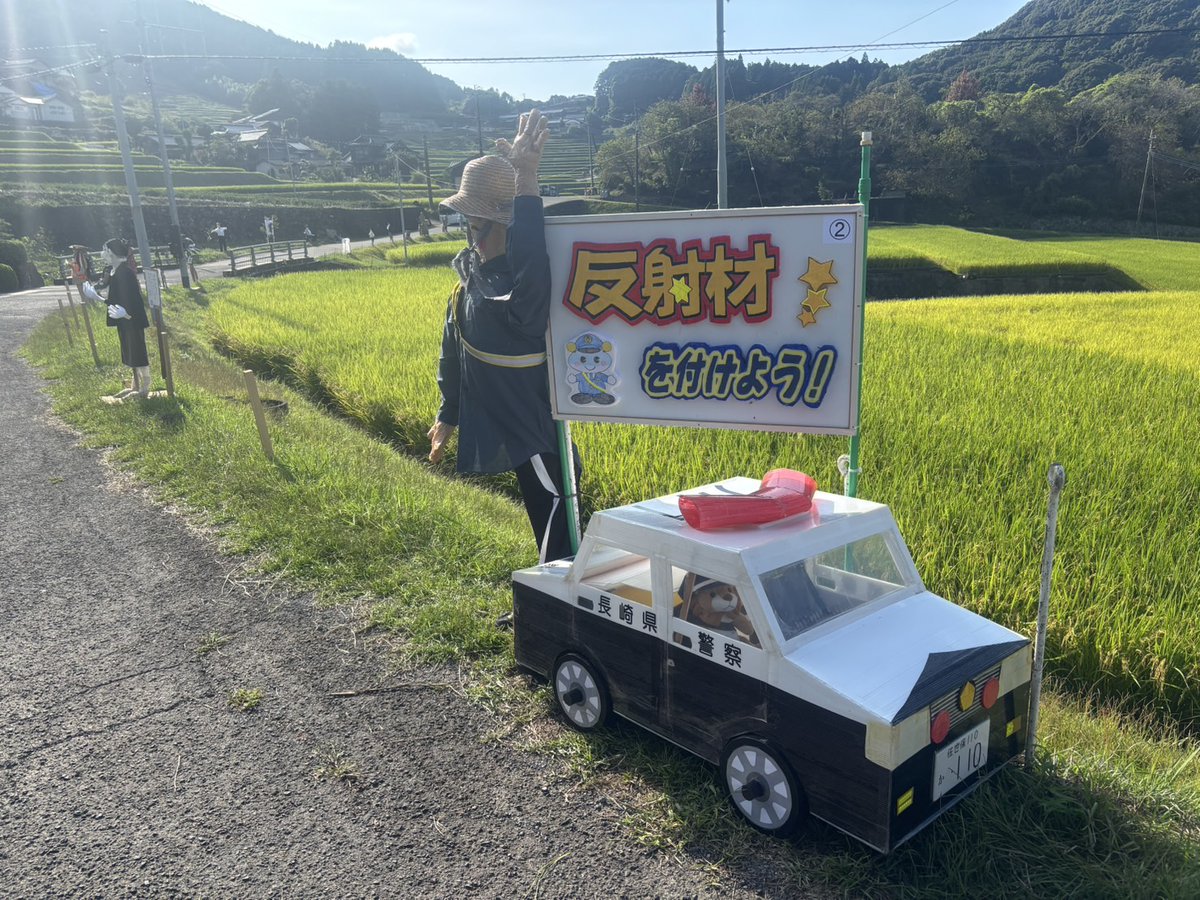 NPP_kikaku's tweet photo. 【#川棚警察署】
　鬼木の棚田は日本の棚田百選に選ばれる人気の観光スポットです。
　見所は棚田に並ぶユニークな「かかし」たち！
　交通安全協会と作成した「かかし」とパトカーを設置中です！
　間もなく秋の全国交通安全運動が始まります。
　反射材を着用して交通事故を防ぎましょう！ https://t.co/sN953go9wg