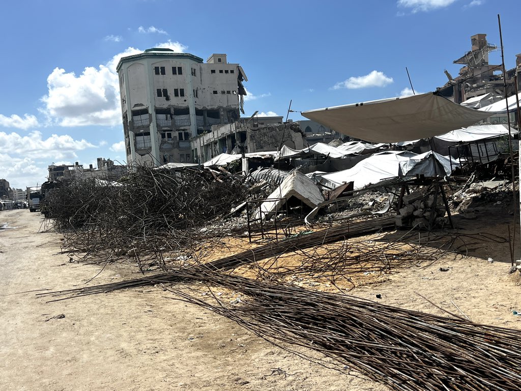 Tamer_Alnoaizy's tweet photo. I took this photo moments ago on one of the streets of Gaza. Perhaps it alone captures the scale of the tragedy we are living through here.

For more than three years, no reconstruction or building materials have entered Gaza City. So what people are doing today is an extraordinary act of resilience in the face of the impossible. They go to destroyed buildings and, among the rubble and twisted metal, use their bare hands and very basic tools to remove the stones trapped in the metal.

After that, they collect the steel rods, straighten and prepare them, and then use them to build tents and temporary shelters.

This work is incredibly difficult, exhausting, and extremely dangerous. People here are not doing this for comfort or to improve their lives. They are doing it because they have no other choice.