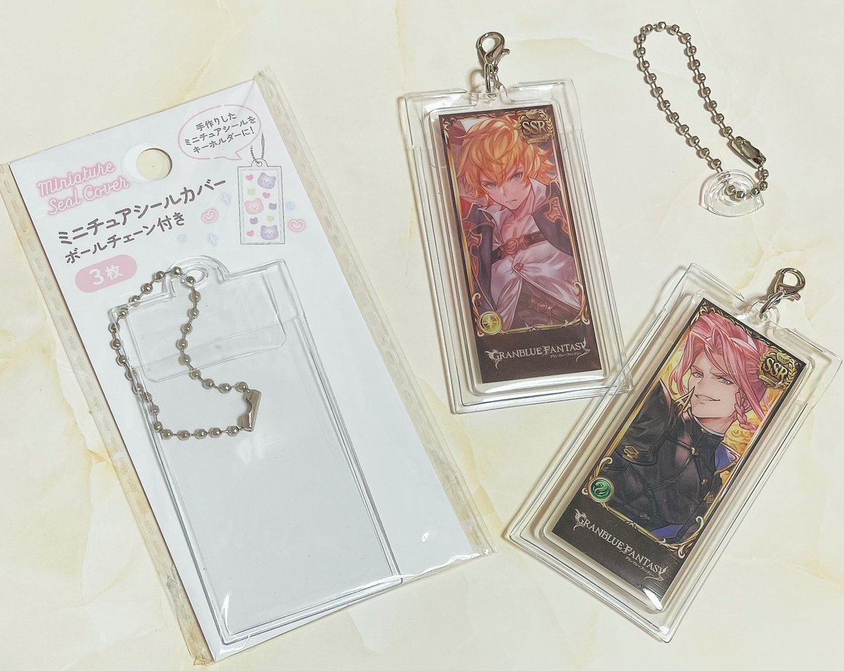 sameko_kbd's tweet photo. ワッツで売っていた「ミニチュアシールカバー　ボールチェーン付き」、編成アクリルチャームのカバーにぴったりだったよ

チャームに付いてるナスカンと出っ張り部分を外に出すために、カバーの上の方を少しカットしているけど、これで絵柄面は保護できる‼️うれしい‼️ https://t.co/vkLF0K5kgR