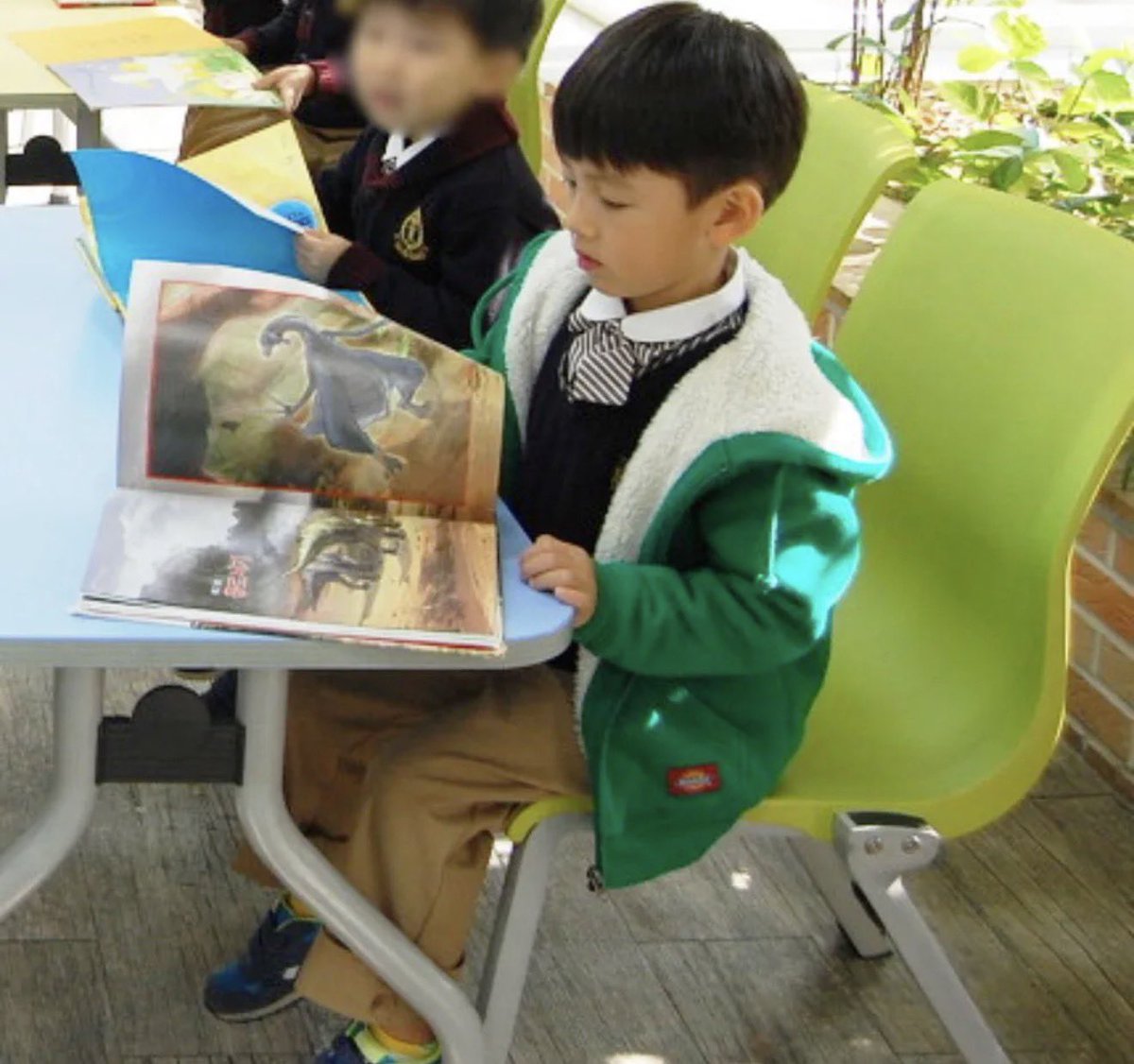 acaijoahae's tweet photo. kok aku baru liat foto seonghyeon kecil yang ini… aku kemana aja pls… sumpah gemes banget dia baca buku cerita tentang dinosaurus gt yah terus bukunya gede banget!! GEMES BGT SI ANAK INI selalu ada aja kegiatannya di sekolah😭🫳🏻 https://t.co/X7MxjeDzeV