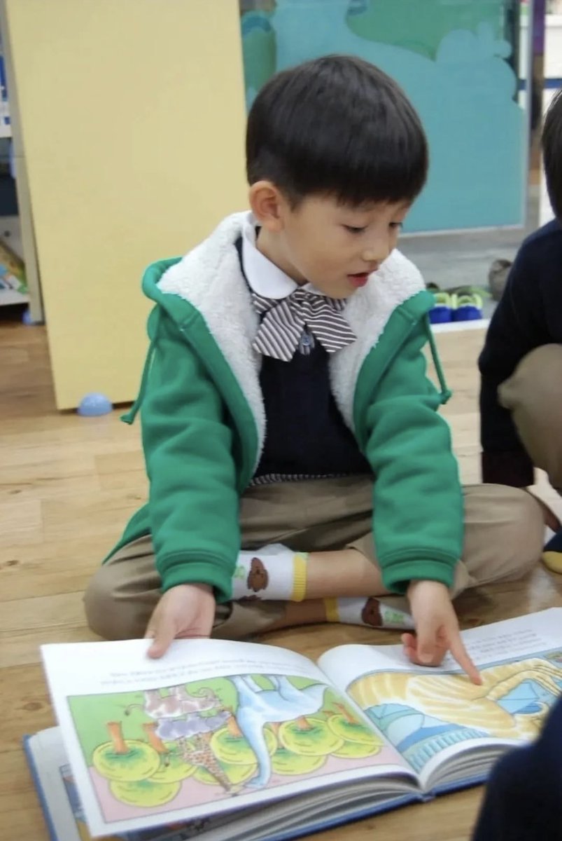 acaijoahae's tweet photo. kok aku baru liat foto seonghyeon kecil yang ini… aku kemana aja pls… sumpah gemes banget dia baca buku cerita tentang dinosaurus gt yah terus bukunya gede banget!! GEMES BGT SI ANAK INI selalu ada aja kegiatannya di sekolah😭🫳🏻 https://t.co/X7MxjeDzeV
