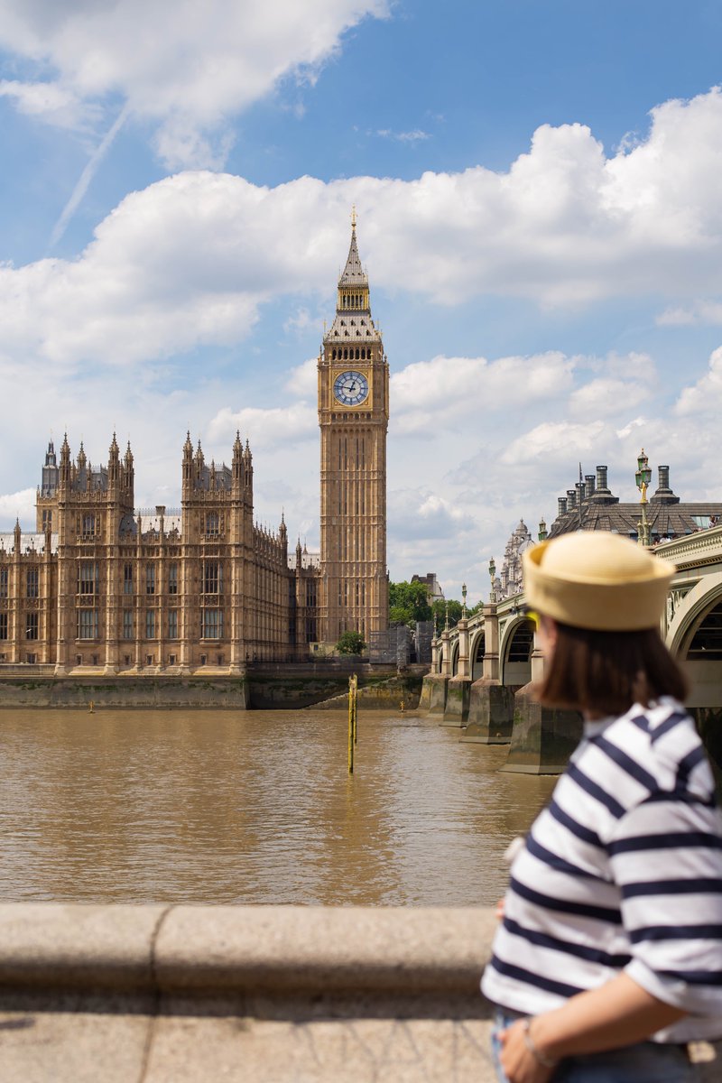 A person looks across the river towards the Palace of Westminster