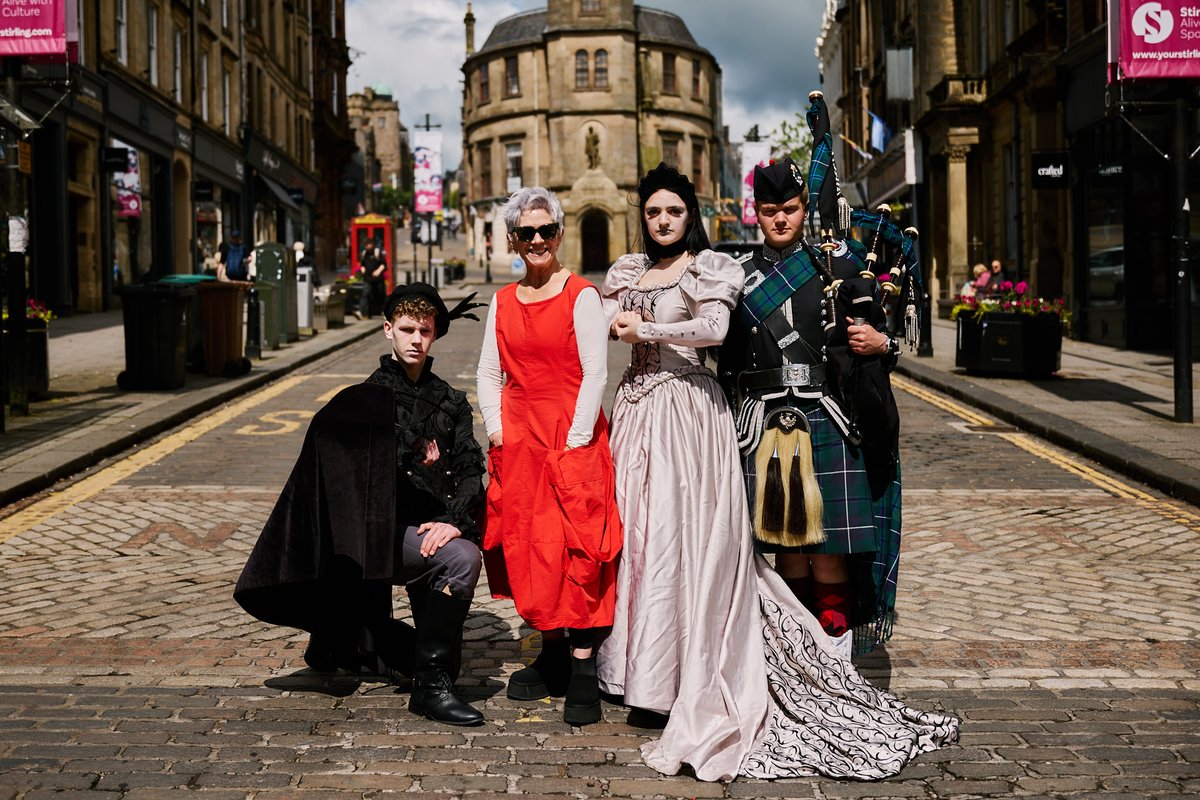 Picture shows guest programmer Denise Mina and costumed actors and a piper on King Street, Stirling