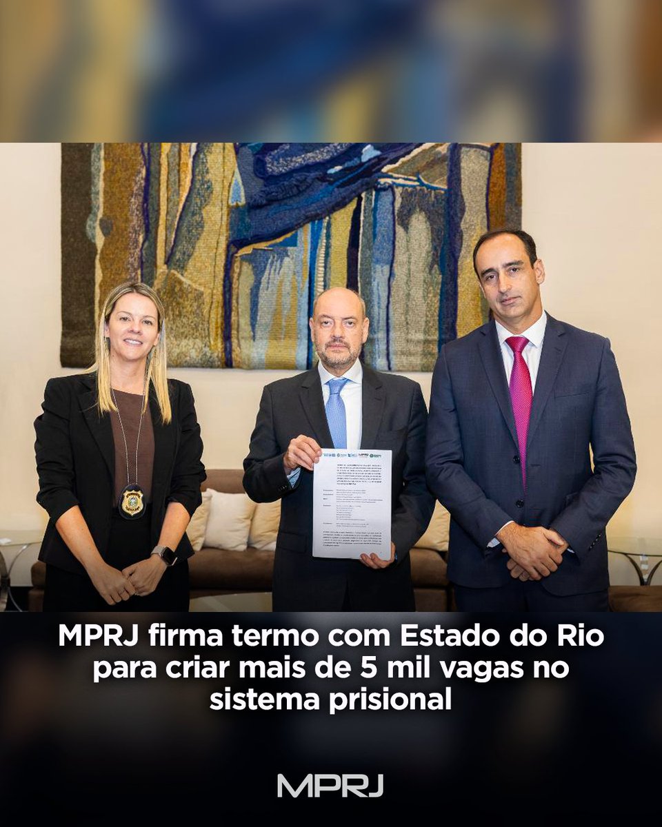 Fotografia de três pessoas posam lado a lado em um ambiente interno. A pessoa ao centro segura um documento impresso diante do corpo. Na parte inferior da imagem, sobre fundo escuro, está escrito em letras brancas: “MPRJ firma termo com Estado do Rio para criar mais de 5 mil vagas no sistema prisional”. Abaixo, aparece a logomarca do MPRJ em cinza.