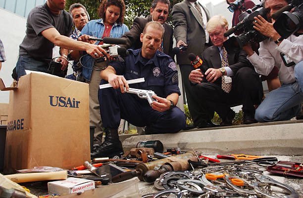 25YearsAgoLive's tweet photo. At a press event, airport security officers at LAX display items they’ve confiscated at security checkpoints today.

After the attacks, airports are reviewing their policies for what passengers can take past security checkpoints. https://t.co/jCZs7ZDPpM