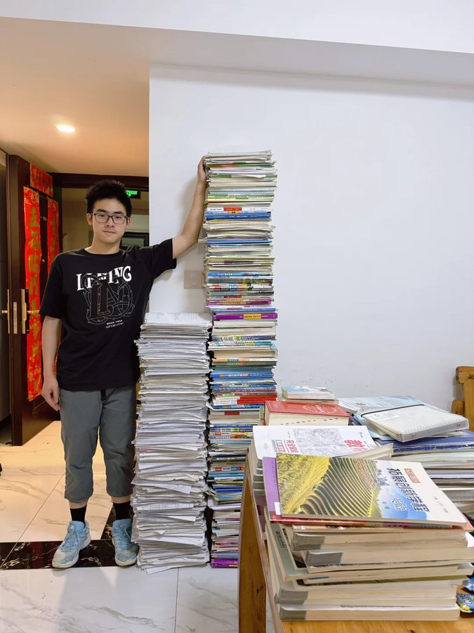 Ma_WuKong's tweet photo. 🇨🇳 Un joven sacándose una foto con todo el material de estudio que se tuvo que preparar para el Gaokao, el examen de acceso a la universidad en China. https://t.co/uP7GBm7PEP
