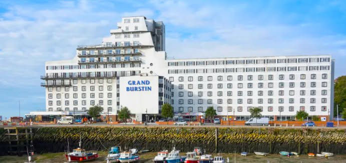 UnityNewsNet's tweet photo. A massive fire has broken out at the Grand Burstin hotel in Folkestone that is said to have housed Asylum Seekers.

It is part of the Britannia hotel chain that is one of the largest providers of accommodation to 'refugees' providing its owner with tens of millions in profit every year.

It is owned by Alex Langsom who himself was classed as a 'jewish refugee' from Europe in the late 1930's.