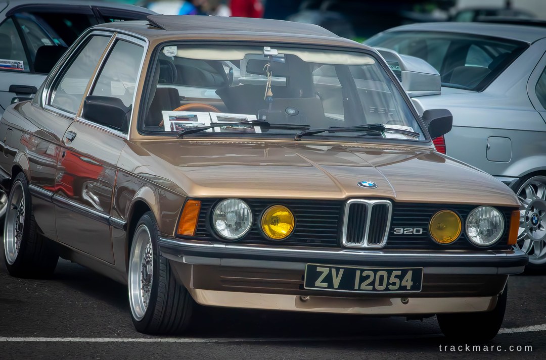 CletaLiburxg's tweet photo. A clean gold E21 BMW 320 rolls through Bimmerfest at Mondello, sitting on deep-dish multi-spoke wheels with classic yellow inner headlamps. Which 3 Series era is your favourite? https://t.co/fW2XT1JoXm