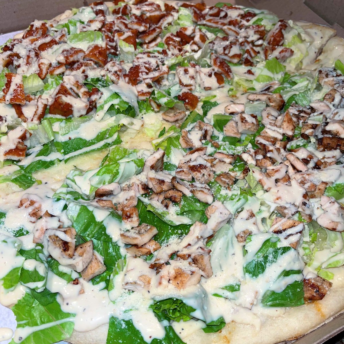 hannahjohniedj's tweet photo. I ordered a Caesar salad pizza with half grilled chicken and half fried chicken. They drew a literal line down the middle, as if the two chickens were about to fight a civil war. https://t.co/spsmsOVX6p