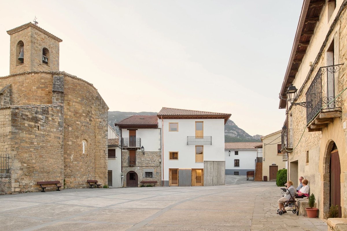 arquitect_viva's tweet photo. Transformación de una vivienda en hotel en Sigüés (Zaragoza)
Sebastián Arquitectos 
https://t.co/lyJC0MT8Sg
En el pequeño pueblo de Sigüés, la arquitectura recupera la memoria de los almadieros, antiguos navegantes del río Esca que bajaban los troncos de los pinos pirenaicos por los rápidos del valle del Roncal.
La rehabilitación transforma una antigua vivienda de la plaza en un pequeño hotel, recuperando elementos existentes y reinterpretando la tradición constructiva local. Una esquina de hormigón incorpora un encofrado de troncos de pino que evoca la geometría de una almadía desaparecida. Un antiguo balcón de forja, recuperado del derribo, vuelve a ocupar su lugar y protege del sol del mediodía.