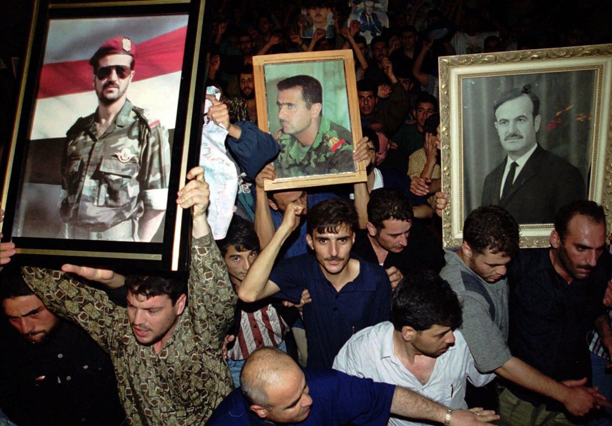 socialistassad's tweet photo. Syrians wave portraits of Hafez, Bashar, and Bassel al-Assad after the passing of Hafez, 2000 https://t.co/mGmGn6eOwt