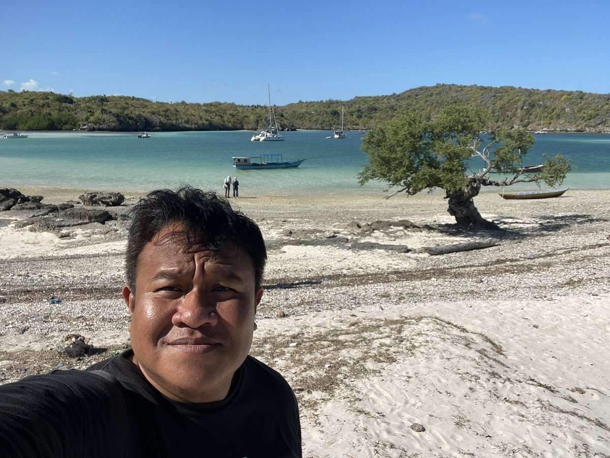 Dandhy_Laksono's tweet photo. ROTE. Baru pertama ke pulau paling selatan NKRI. Lanskapnya sering digambarkan kering dan tandus. Warganya banyak merantau. 

Dengan propaganda itu, Jakarta sedang bikin proyek 13.000 Ha tambak garam (setara luas sawah) yang menggusur tanaman pangan manusia dan ternak, serta mengancam sumber air. Terutama di sisi timur pulau.

Proyek ini di bawah bendera K-SIGN (Kawasan Sentra Industri Garam Nasional). Seperti biasa, iming-imingnya penciptaan 25.000 lapangan kerja. 

Padahal Rote sudah swasembada pangan (beras, jagung, ubi, sorgum). Sebagian bahkan dijual ke Kupang (Timor daratan).

Seperti Proyek Strategis Nasional (PSN) lain di seluruh NKRI, warga dan pemerintah daerah tak pernah dilibatkan dalam perencanaan. Semua diputuskan Jakarta. 

Punya produksi garam tentu penting. Tapi membebankan produksi nasional pada satu pulau kecil, adalah penghancuran dan pemiskinan. Apalagi di sisi barat, industri pariwisata premium terus mengincar tanah-tanah masyarakat.

Sementara pusat-pusat produksi garam seperti utara Jawa atau Madura semakin hancur karena tekanan industrialisasi dan komersialisasi lahan. Seperti di Sulawesi untuk reklamasi properti. 

Garam tak hanya buat masakan. Juga industri farmasi, kecantikan, tekstil hingga kimia. Kalau benar demi ekonomi Rote, buka tambak secukupnya lalu bangun industri hilirnya. 

Ini yang akan menciptakan lapangan kerja. Bukan belasan ribu hektar hamparan tambak yang cukup dengan alat-alat berat dan hanya perlu segelintir buruh kasar saja. 

Pemerintah daerah jangan obral lahan dan tertipu dengan iming-iming lapangan kerja. Stop membuka lahan baru sampai Jakarta membangun industri hilir di Rote.

Tanpa hilirisasi, proyek ini hanya mengincar lahan murah dan mudah. Korbannya akan banyak. Dari lontar, ternak, hingga potensi wisata.

Kalau perlu pemerintah NTT dan Rote Ndao membuat syarat bahwa setiap 1.000 Ha lahan yang dibuka, harus ada 1 rintisan industri hilir yang dibangun.

Apalagi semua pemerintah daerah sedang dilemahkan lewat fiskal yang terus disedot rezim militeristik Prabowo-Gibran di Jakarta.

Daerah seperti Rote hari ini tak bisa membangun dan hanya sanggup membayar gaji pegawai. 

Saya sampaikan salah satu konsep dan gagasan dari buku "Reset Indonesia" ini di forum Rote Mengajar, Agustus lalu di depan bupati, pejabat, ASN, dan warga.

Semoga didengar. Kalau tidak, ingatlah: Ini pulau paling selatan NKRI.

Tahu apa yang terjadi dengan mereka yang kecewa di ujung paling barat dan timur NKRI?