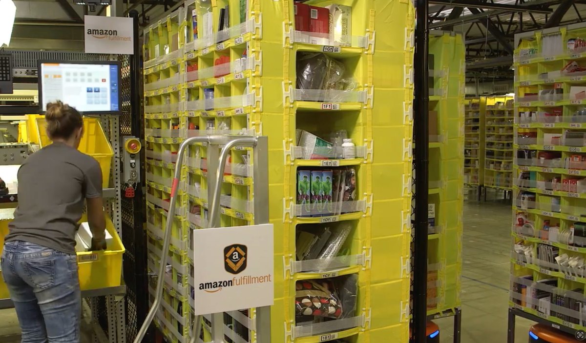 sipalinglogstic's tweet photo. Tau ga, kalo kamu main ke gudang retail di Indo, barang tuh rapi banget dipisah per zona? Zona elektronik kumpul sama elektronik, zona baju sama baju. Tapi kalo kamu liat video gudang Amazon (Fulfillment Center), barangnya ditaruh ngasal aja di rak mana pun yg kosong? Kok bisaa beda metodenya ya?

Kalo di gudang lokal kita, sistem zona (dedicated storage) masih kepake banget karena operasionalnya masih sangat ngandelin "ingatan visual" manusia. Pekerja gudang harus hafal secara fisik, "oh lorong B itu buat elektronik, lorong C buat sabun."

Nah, berdasarkan jurnal Innovation Management and Automated Accounting in the Chaotic Storage Logistics (2020), sistem ngasal ala Amazon (mereka nyebutnya chaotic storage) itu menuntut otomatisasi dan WMS (Warehouse Management System) yg super canggih. Di Amazon, worker gausah ngapal lokasi. Worker cuma butuh scan barcode barang dan scan barcode rak, terus algoritma komputer yg jadi "otak" buat nginget semuanya real-time.

Alasan kedua kenapa Amazon milih ditaruh ngasal adalah soal ruang kosong (space utilization). Kamu bayangin deh, kalo pake sistem zona, pas zona sabun lagi penuh pesenan dari supplier, sabun2 beterbaran ini ga bisa ditaruh di zona buku walaupun lorong buku lagi kosong melompong. Banyak ruang nganggur.

Ini dibahas dalam penelitian Batt & Gallino (2018) soal pick-worker performance. Menurut riset mereka, chaotic storage ngakalin masalah itu. Kalo ada ruang kosong sekecil apa pun di rak gudang Amazon, barang baru bisa langsung masuk situ. Sikat gigi bisa nyempil di sebelah buku atau kabel charger. Hasilnya? Kepadatan gudang jadi maksimal dan gak ada lorong yg nganggur.

Terus ada masalah yg paling bikin capek pekerja gudang: pegel jalan kaki alias travel time.

Kalau kamu baca buku manajemen logistik World-Class Warehousing and Material Handling dari Edward H. Frazelle, dia ngasih fakta menarik: lebih dari 50% biaya tenaga kerja di gudang itu habis cuma buat waktu pekerja berjalan mondar-mandir ngumpulin order!

Lha bayangin di gudang sistem zona, ada customer pesen 1 TV dan 1 sikat gigi. Pekerja harus jalan dari ujung barat ke ujung timur gudang cuma buat ngambil dua barang itu. Kalau di Amazon? Karena sikat gigi dan TV disebar secara acak di ribuan titik di seluruh gudang, pas pesenan masuk, komputer bakal langsung nyari di mana letak TV dan sikat gigi yang posisinya paling deket dari si pekerja saat itu. Jalan kaki jadi jauh lebih irit.

Makanya di kebanyakan amazon fulfillment center juga mereka pake robot tuh rak2nya yg datengin picker ke station, pickernya diem aja ga usah kemana2.

Tapi pertanyaannya, apa gudang retail di Indo ketinggalan zaman banget karena masih pake zona? Ngga juga.

Ada makalah akademik terbaru di jurnal Taylor & Francis soal Heterogeneous products allocation yg jelasin kalo sistem zona itu tetep juara dan wajib dipakai utk kondisi barang tertentu. Kalo barangnya butuh penanganan fisik khusus—misalnya rak palet besar yg butuh akses forklift, barang kimia berbahaya, atau butuh ruangan pendingin—sistem zona itu pilihan paling logis dan aman buat keselamatan kerja.

Gudang bersistem zona di Indo itu disetting pakai logika navigasi manusia biar gampang dikelola secara fisik, apalagi buat barang2 berat atau khusus. Sedangkan gudang Amazon milih jadi "berantakan" karena mereka murni pakai logika algoritma. Mata kita lihatnya acak2an, tapi buat sistem mereka, itu adalah puncak rantai efisiensi.