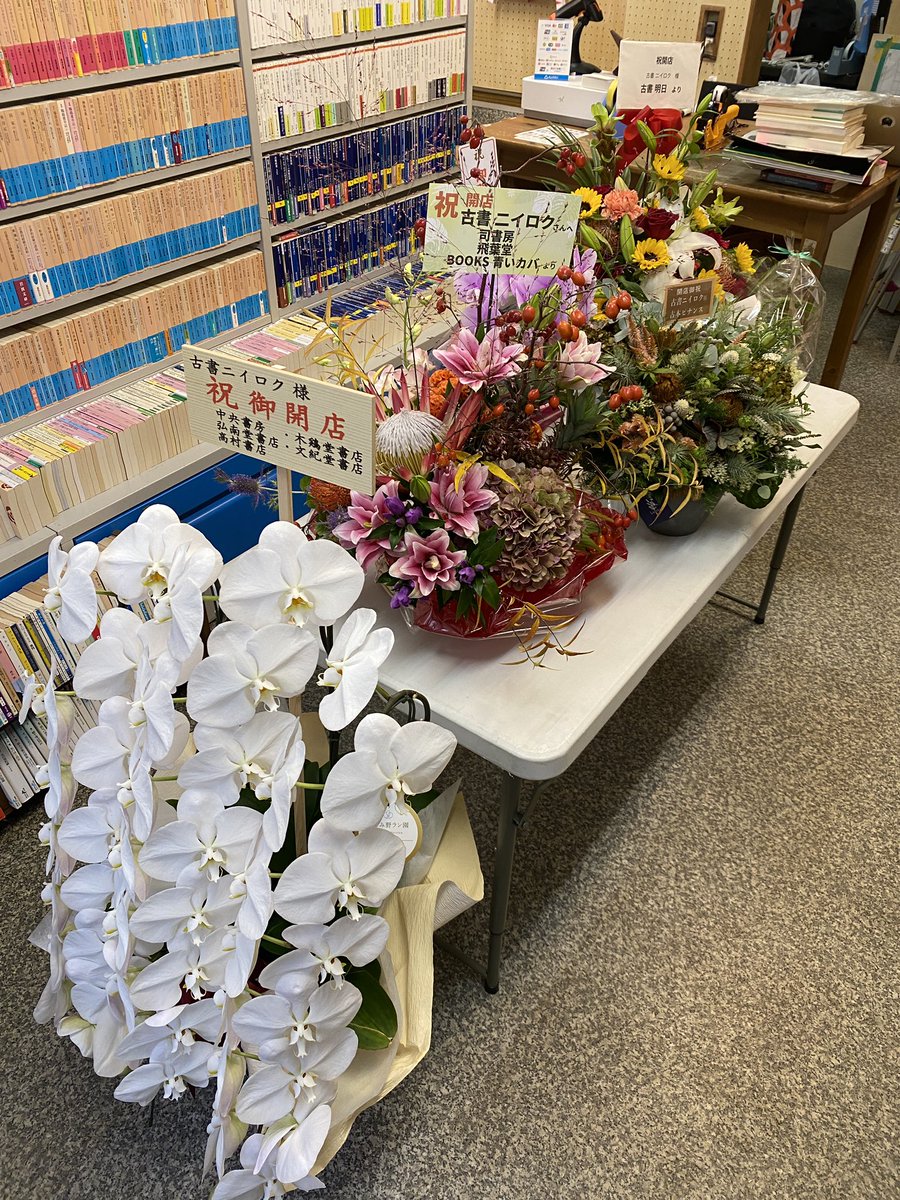 kosho_26's tweet photo. 本日12時、古書ニイロク無事オープンしました！

家族友人や古本屋の先輩仲間たちからたくさん花を送っていただき幸せです！

天気も雨模様ですが大荒れではないので本日20時まで営業予定です。

明日の営業につきましては夜の天気予報を見てまたアナウンスいたします🙇‍♂️

#古本屋 #開店 #世田谷区 #奥沢 #古本買取