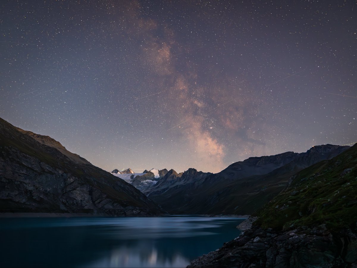 WirthSteven's tweet photo. The Milky Way over the Swiss Alps on a summer’s night.  There’s a lot of Starlink activity visible. https://t.co/qLVy2XePg1
